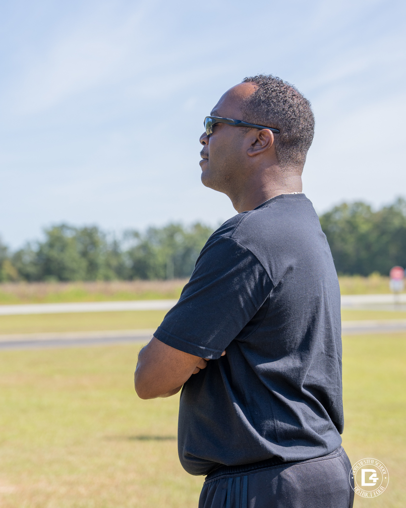 Chaplain MAJ (USA Retired) John Logan Jr. observes cadets during outdoor physical training on the back lawn.