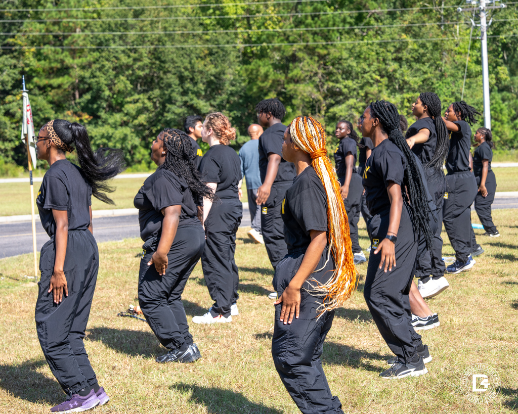 A large group of Woodland High JROTC cadets move in formation during physical training, led by their peers.