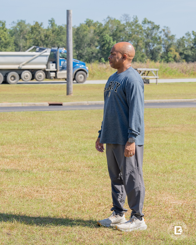 Sergeant (Ret.) Kevin Simpson stands on the field, overseeing cadets during student-led PT at Woodland High.
