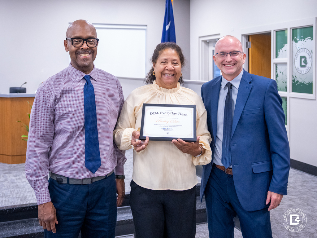 Shirley Eskew, teacher at Odyssey Educational Center, holds her DD4 Everyday Hero certificate while standing with Principal Dr. Jeffery Thompson and Superintendent Jeffrey Beckwith at the recognition ceremony.