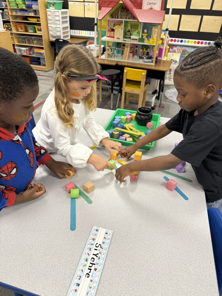 Students in Mrs. Forest’s Pre-Kindergarten class at Williams Memorial Elementary School work together on a Halloween-themed STEM challenge. Each group uses colorful blocks, linking cubes, and craft sticks to build a gate for five little pumpkins after reading Five Little Pumpkins. Children dressed in costumes—princesses, superheroes, and storybook characters—focus intently as they design, test, and adjust their creations, demonstrating teamwork, problem-solving, and persistence.