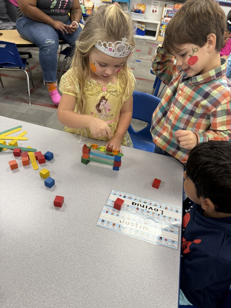 Students in Mrs. Forest’s Pre-Kindergarten class at Williams Memorial Elementary School work together on a Halloween-themed STEM challenge. Each group uses colorful blocks, linking cubes, and craft sticks to build a gate for five little pumpkins after reading Five Little Pumpkins. Children dressed in costumes—princesses, superheroes, and storybook characters—focus intently as they design, test, and adjust their creations, demonstrating teamwork, problem-solving, and persistence.
