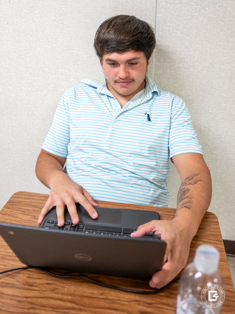 Student sits at a desk in a classroom setting, participating in the virtual career fair and exploring various career pathways.