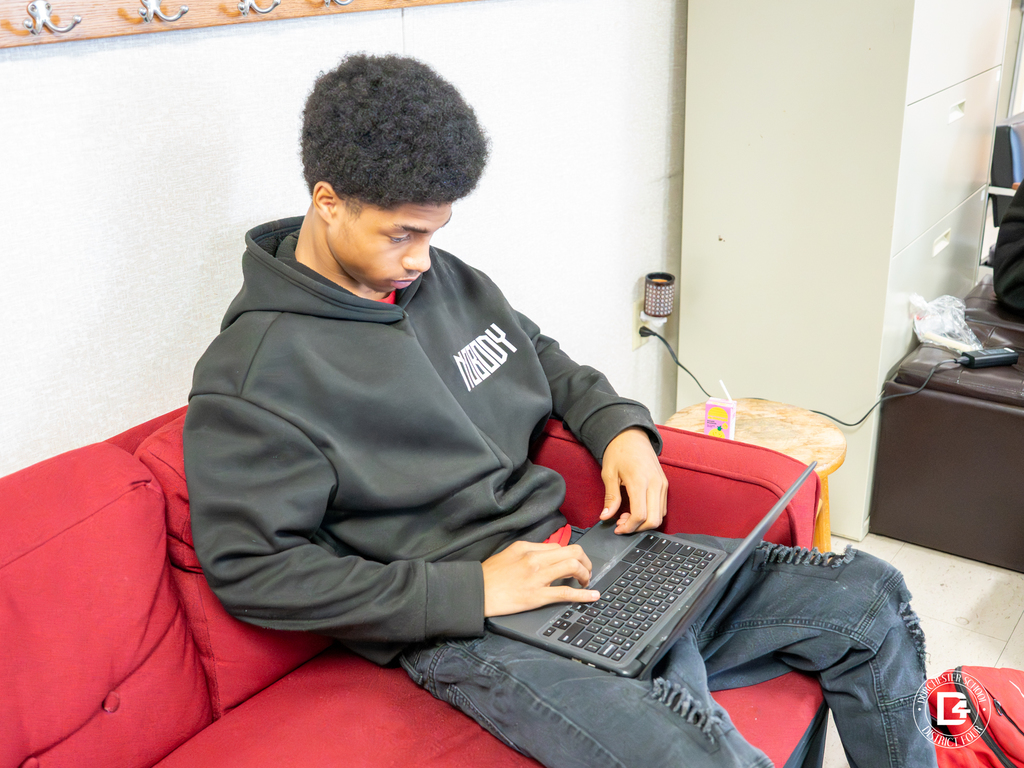Odyssey Educational Center student participates in the virtual career fair from a comfortable seating area, using a laptop to connect with career professionals.