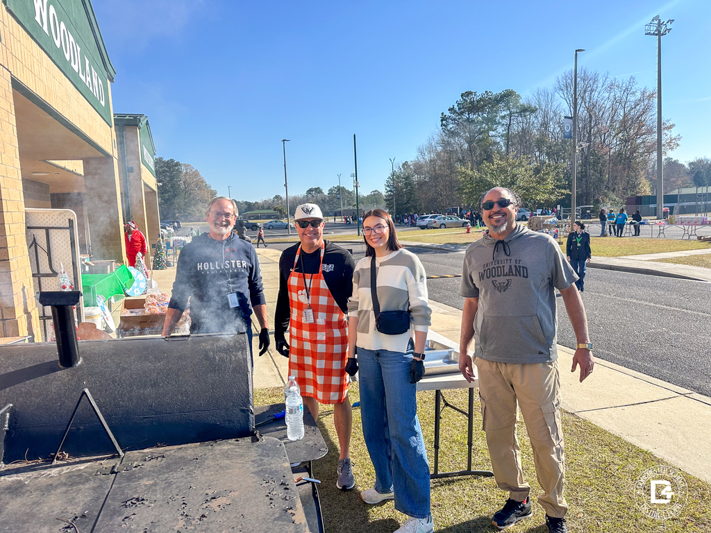 Volunteers and staff stand beside a grill outside Woodland High School, preparing food for families during Christmas at DD4.