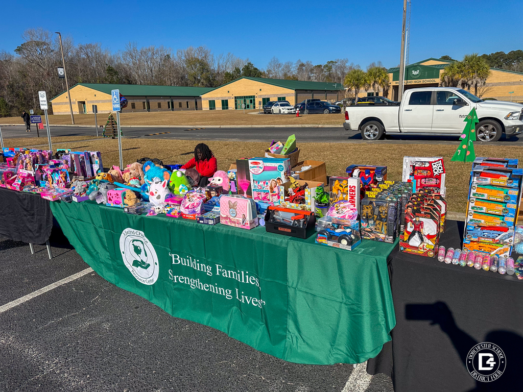 A wide view shows multiple tables filled with donated toys and gifts provided by A Second Chance Resource Center and other sponsors.