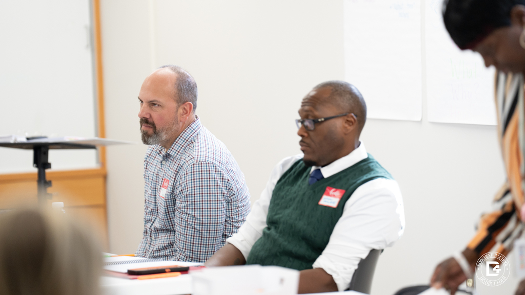 Teachers seated at a table during Dorchester School District Four mentor training, listening and discussing mentor strategies with a facilitator.