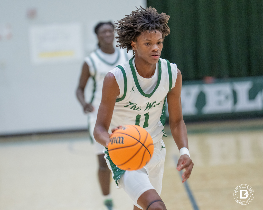 Jhailen Herrin pushes the ball up the court in transition, focused and composed, teammate trailing behind.