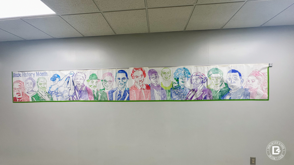 Long horizontal mural labeled “Black History Month” featuring a row of hand-drawn portraits of influential Black leaders in bright colors across the wall.