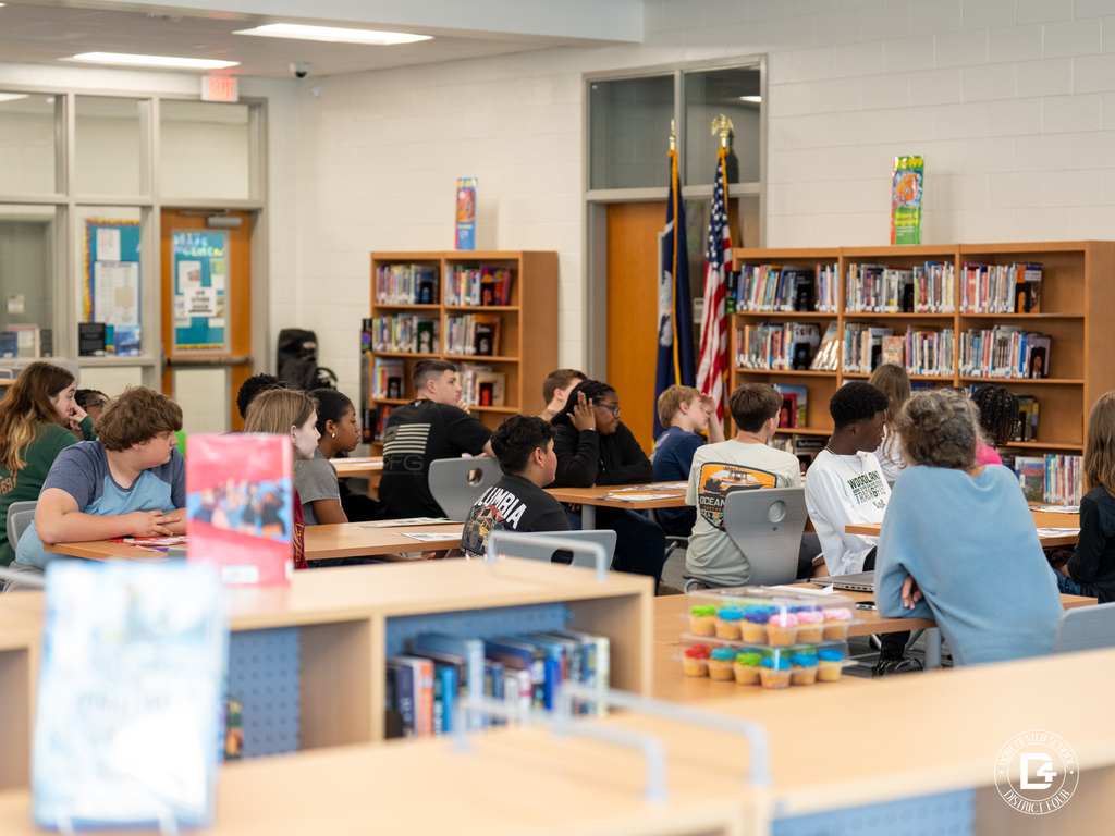 Students sit at tables in the library listening attentively as the speaker discusses leadership and future opportunities.