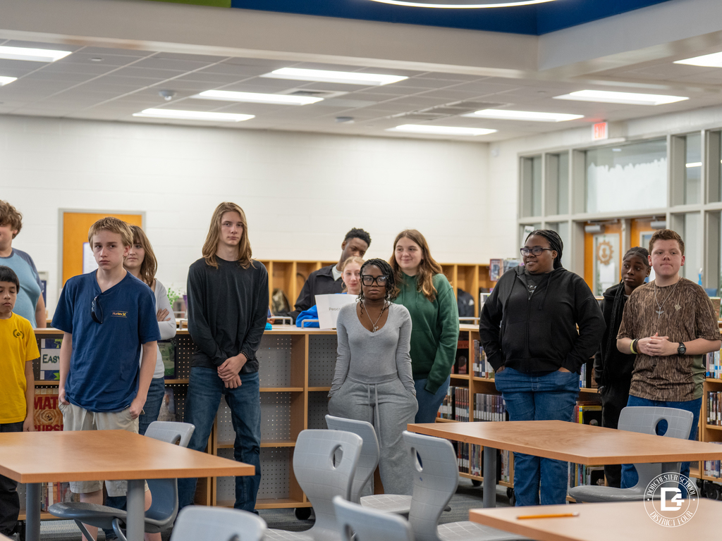 Students stand together in the library during the ProTeam class activity and discussion.
