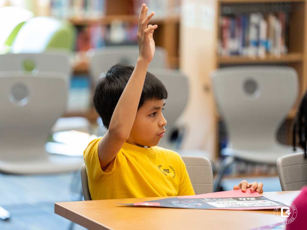Student raises his hand to participate in the leadership discussion during the ProTeam class.