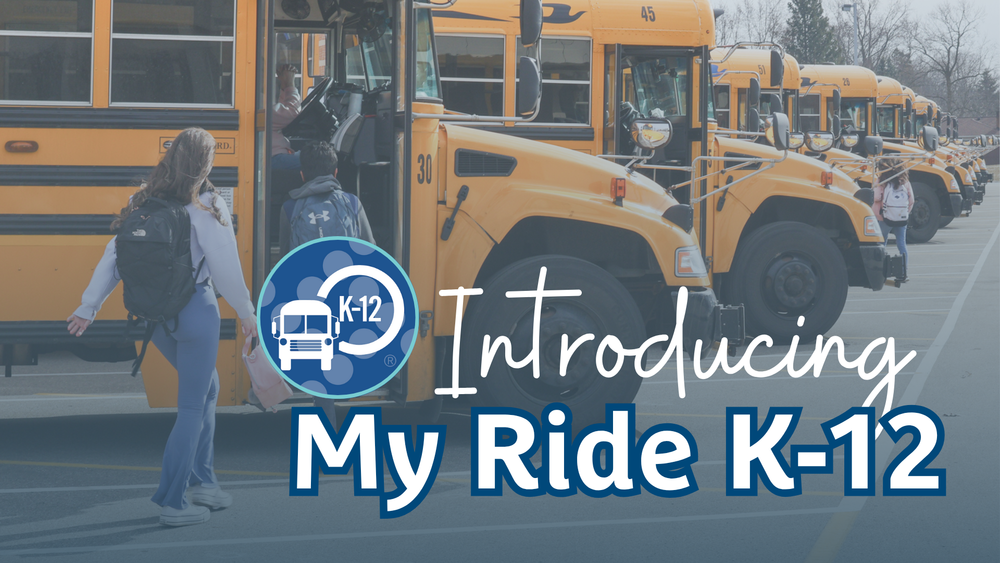 Promotional banner introducing 'My Ride K-12,' a school bus tracking or transportation app. The background shows a row of yellow school buses with students boarding. A circular logo featuring a school bus icon and 'K-12' label appears on the left, alongside the text 'Introducing My Ride K-12' in white and bold blue lettering.