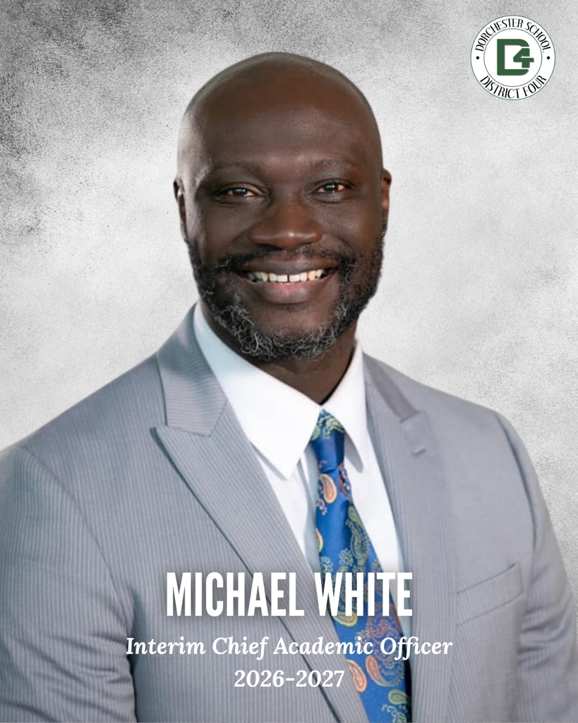 Headshot of Michael White, Interim Chief Academic Officer for Dorchester School District Four, 2026–2027. He is smiling and wearing a gray suit with a blue paisley tie. The Dorchester School District Four logo appears in the upper right corner.