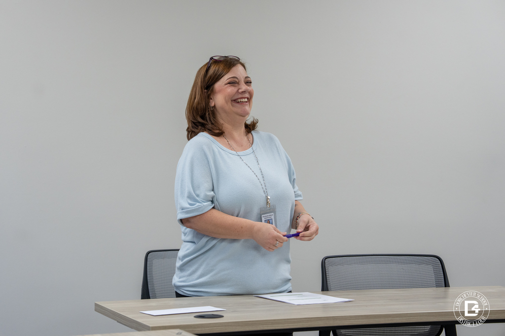 A Dorchester School District Four staff member smiles while standing at the front of a meeting room during the Assistant Principal’s Academy session.