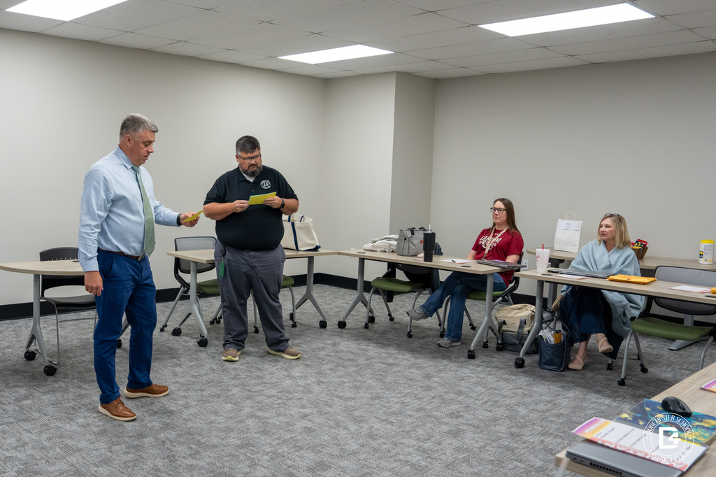 Dorchester School District Four Public Relations Director Mr. Lakin and another district staff member stand at the front of a meeting room while participants sit at tables during the final Assistant Principal’s Academy session.