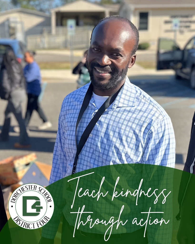 Smiling male staff member stands outdoors during a community food drive or service event. The graphic includes the Dorchester School District Four logo and the phrase “Teach kindness through action.”