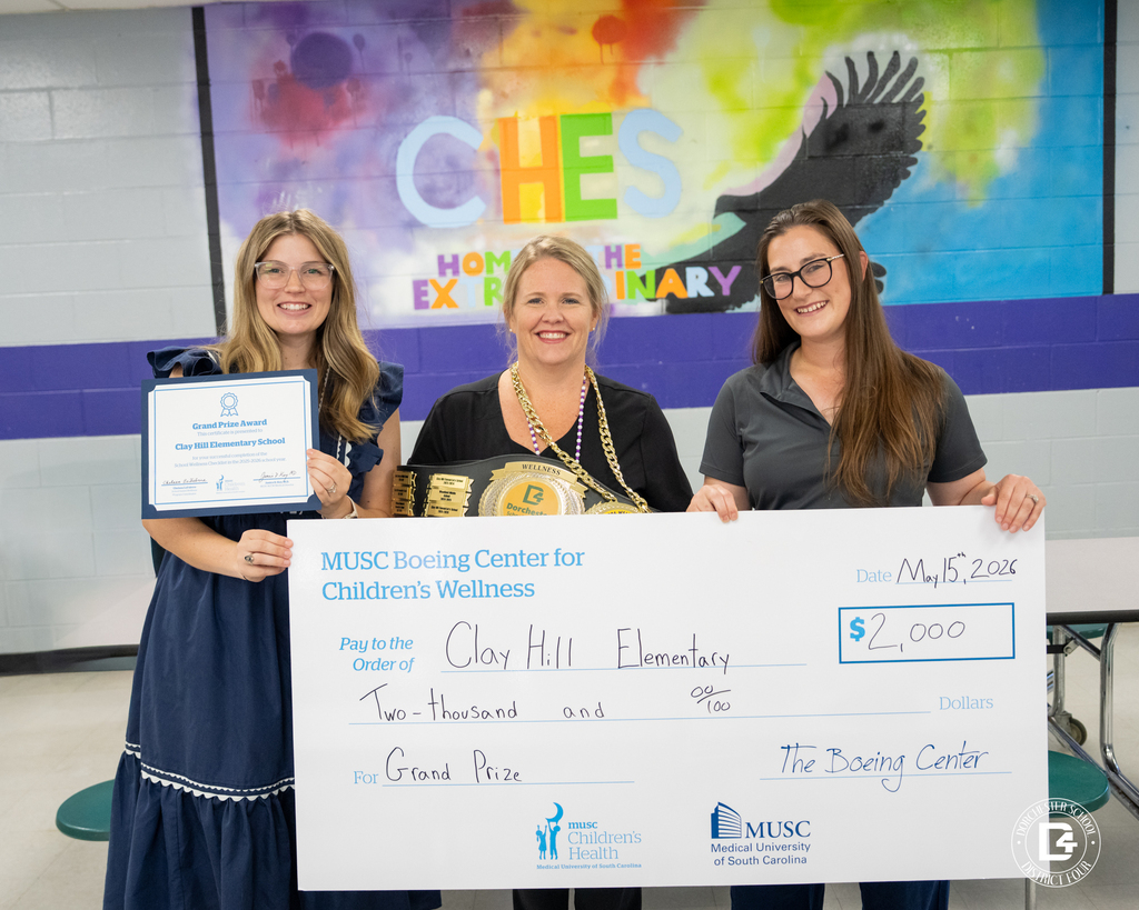 Nurse Weathers poses with two MUSC representatives with a certificate and a large $2,000 MUSC Boeing Center for Children’s Wellness award check in front of a colorful CHES mural.
