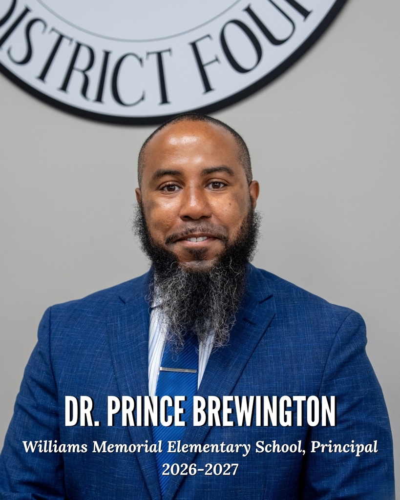Portrait of Dr. Prince Brewington, Principal of Williams Memorial Elementary School for the 2026-2027 school year. He is seated facing the camera, wearing a blue suit jacket, blue tie, and striped dress shirt. He has a closely shaved head and a full beard with gray accents. The background features a portion of the Dorchester School District Four seal. Text on the image identifies him as "Dr. Prince Brewington, Williams Memorial Elementary School, Principal, 2026-2027."