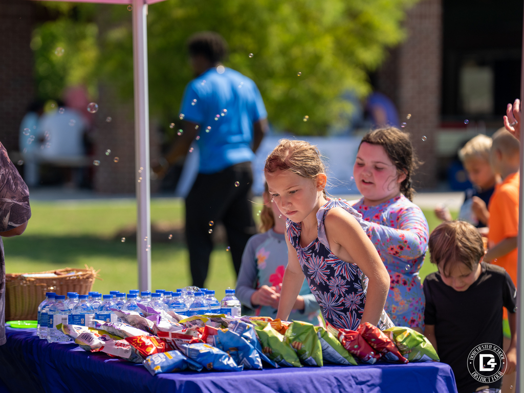 Children choose snacks and water at the YMCA activity station during the Splash Into Safety event.