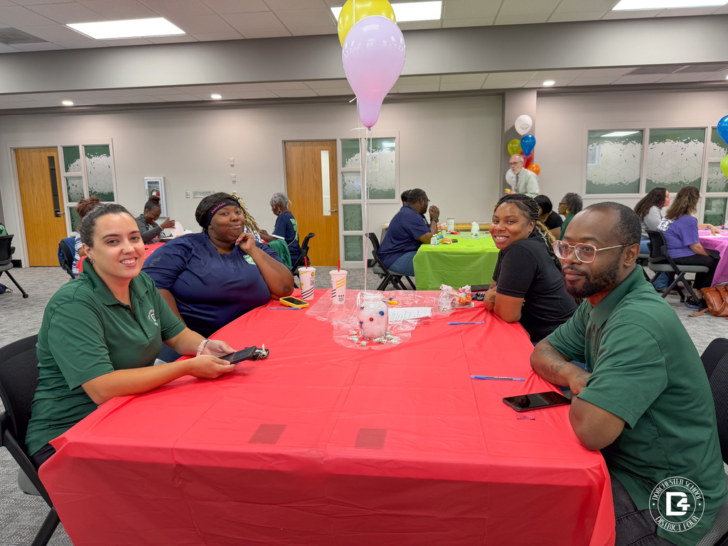 Four DD4 Food Services team members sit together at a decorated table during the district's annual in-service event.
