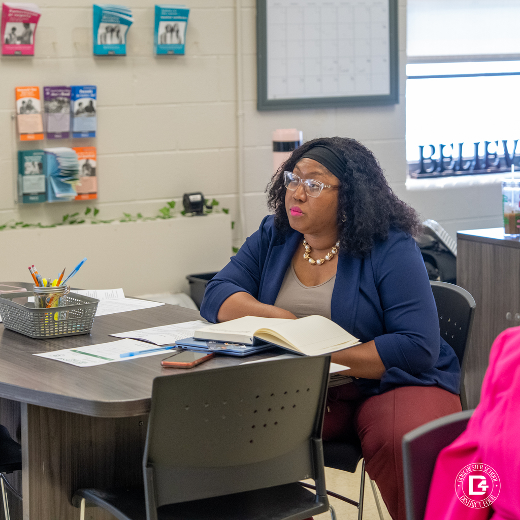 Community member seated at a table with notes during the mentoring program orientation.