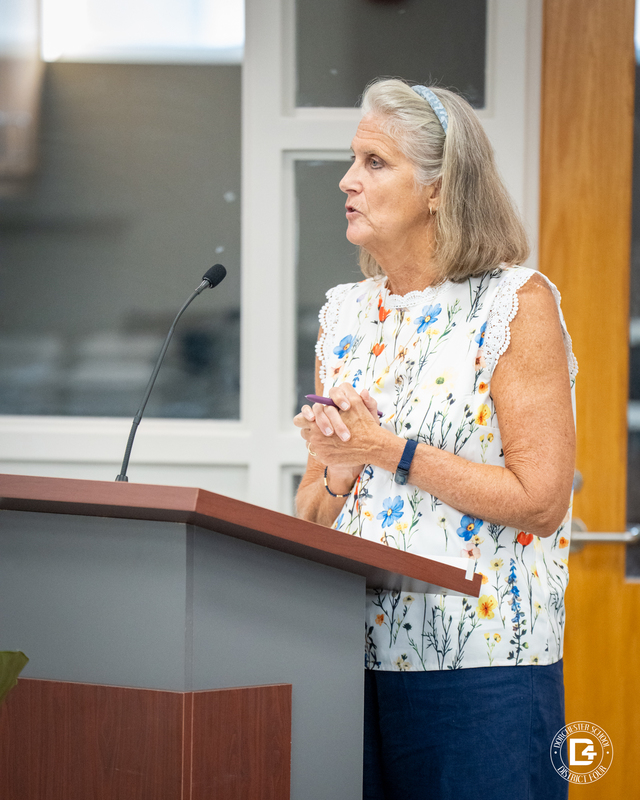 Ruth Mims, Williams Memorial Elementary Principal A woman in a floral blouse stands at a podium, speaking with her hands clasped during the board meeting.