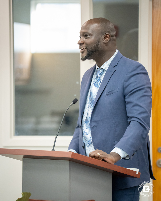 Michael White, Woodland A man in a blue suit and patterned tie speaks at a podium with a microphone, smiling while addressing the board.High School Principal 