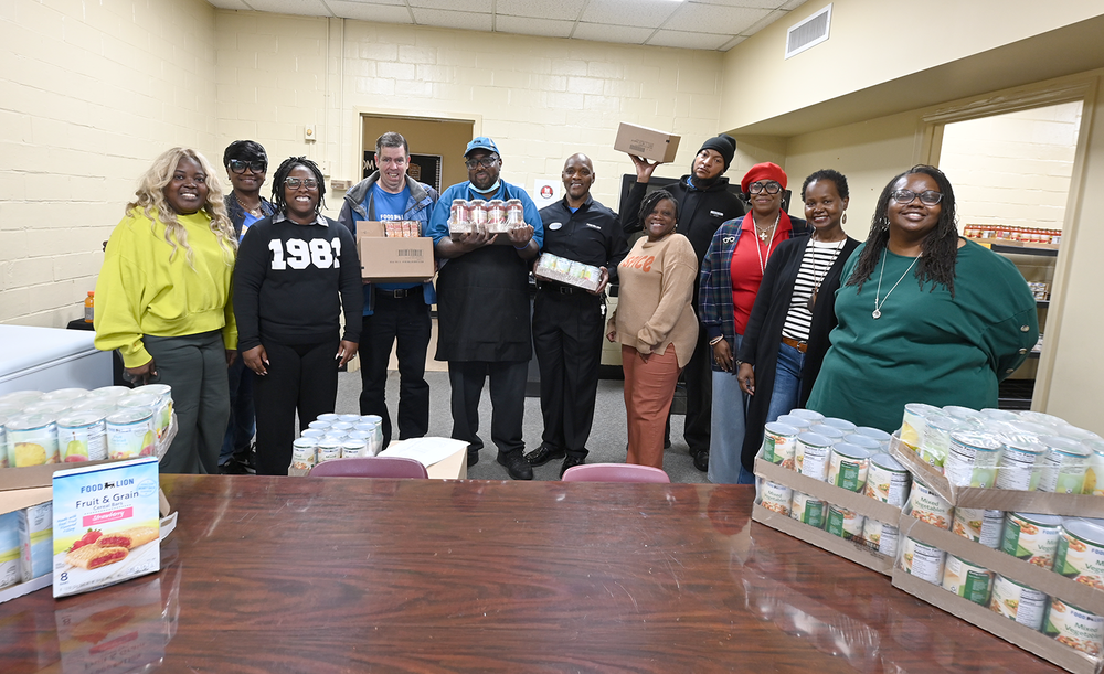 Food Lion workers and members of the district's family and community engagement team pose for a photo