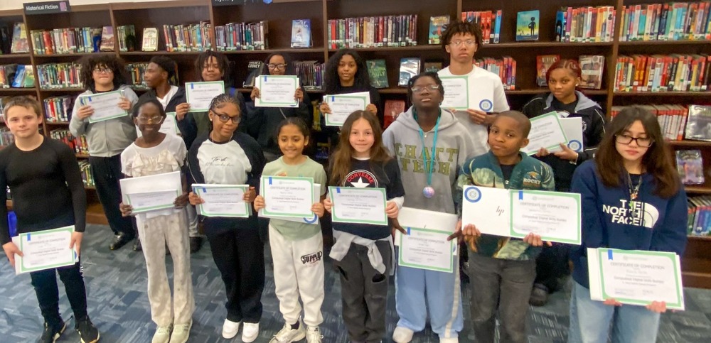 Stewart Middle students hold up their certificates for completing a special computer seminar that earned them free laptops.