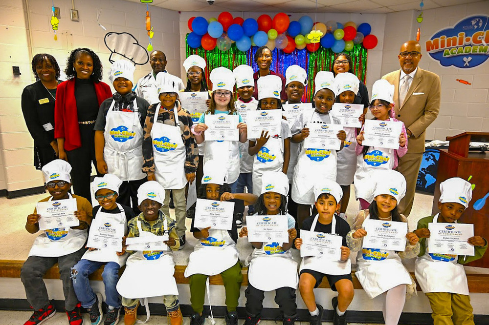 Group photo of the Mini Chef Academy 2026 graduates at Sweetwater Elementary with Dr. Charlie Rouse, Principal Tanish Springer, Superintendent Dr. Trent North and teacher Niamba Johnson.