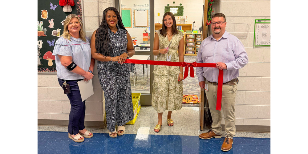 A Bill Arp teacher cuts the ribbon in front of her classroom with Bill Arp administrators present.
