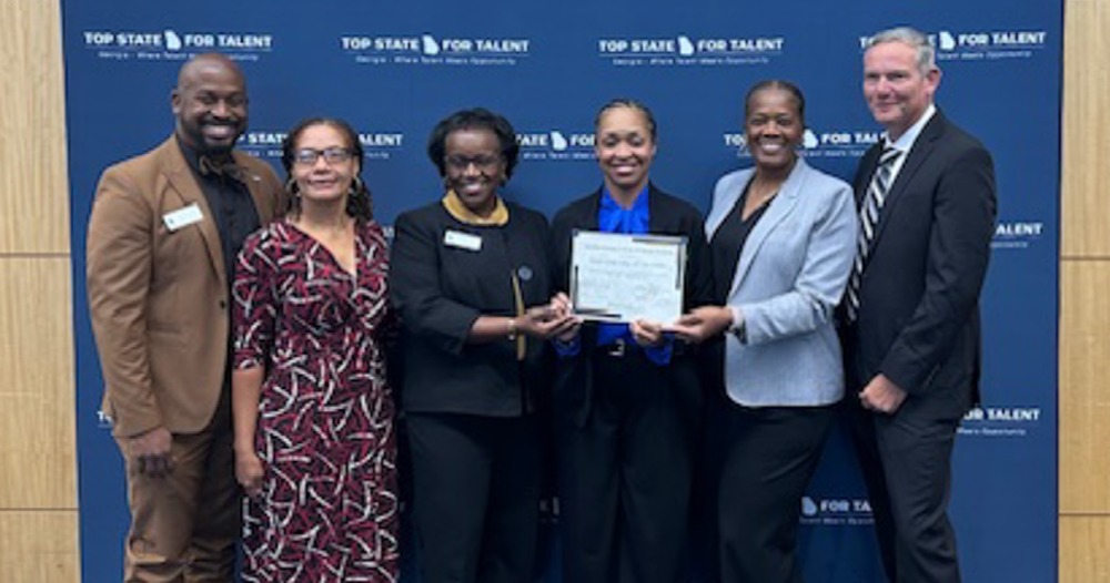 CCI Principal Bakahai Litman and staff with their recertification certificate.