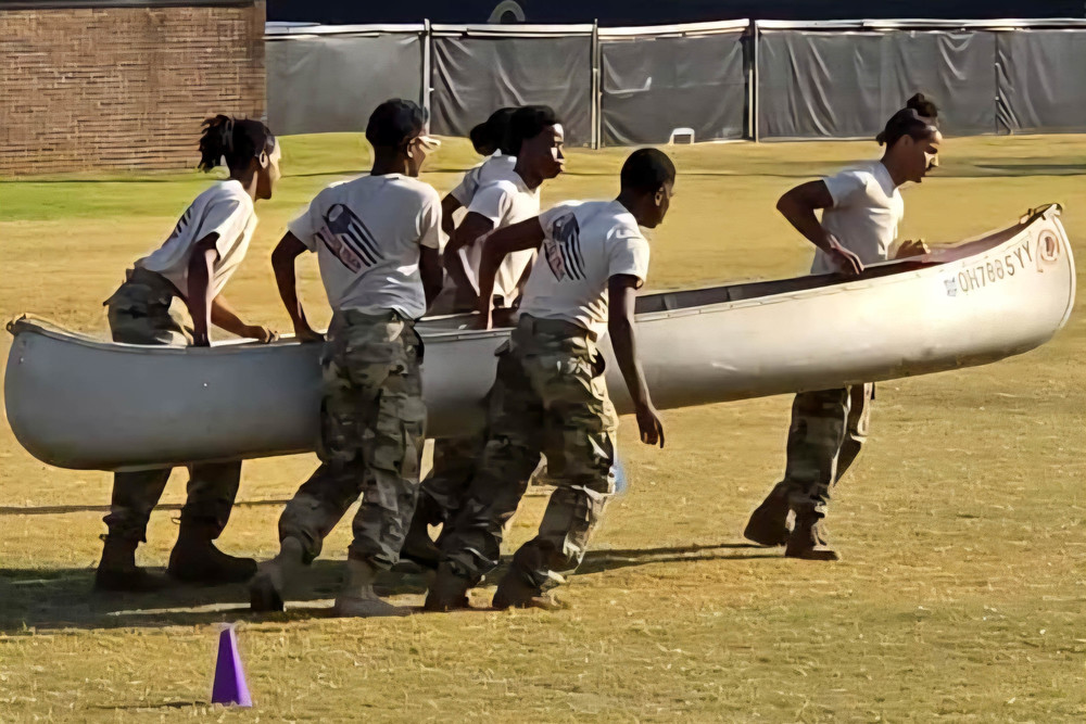 NMHS Raiders carry a canoe during a challenge.
