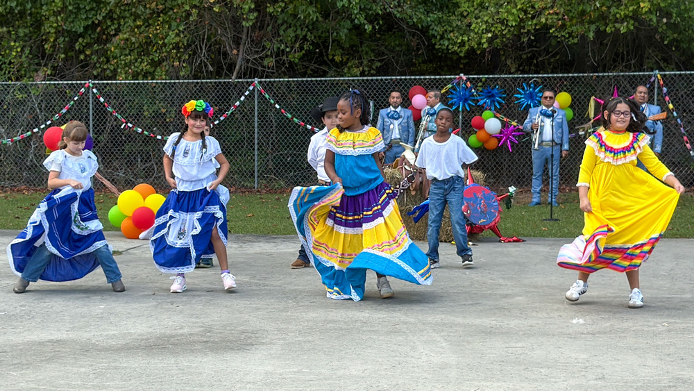 Students at Lithia Springs Elementary in colorful dresses dance for the Hispanic Heritage event.