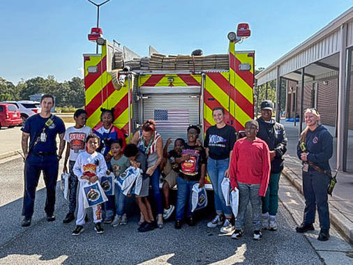 DCSS students with firefighters during a Touch a Truck event.