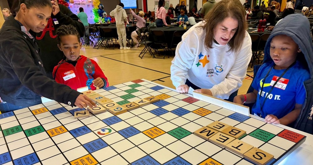 Students, parents and staff work on a special STEM Scrabble board at Google Family STEM Day at Factory Shoals Elementary