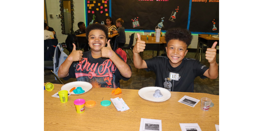 Arbor Station students smile while taking part in a science activity.