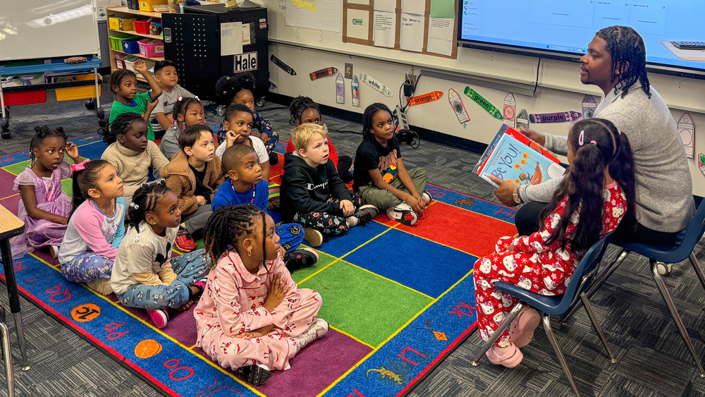 A male role model reads to a class at Mount Carmel Elementary.