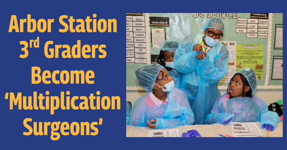 Arbor Station Elementary third graders in blue surgical gowns, caps, masks and gloves gather around a table in a classroom. A teacher holds up a small green vial while the students look on. Text reads: “Arbor Station 3rd Graders Become ‘Multiplication Surgeons.’”