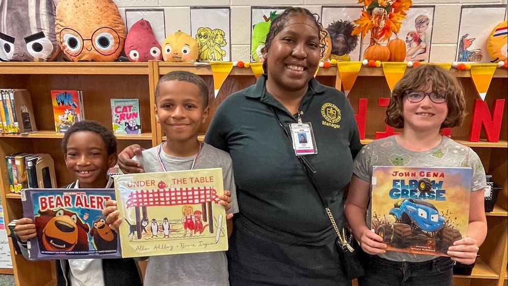 CHES students and cafeteria manager with books.