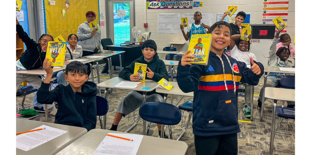 Chestnut Log studens hold up copies of a Nic Stone book.