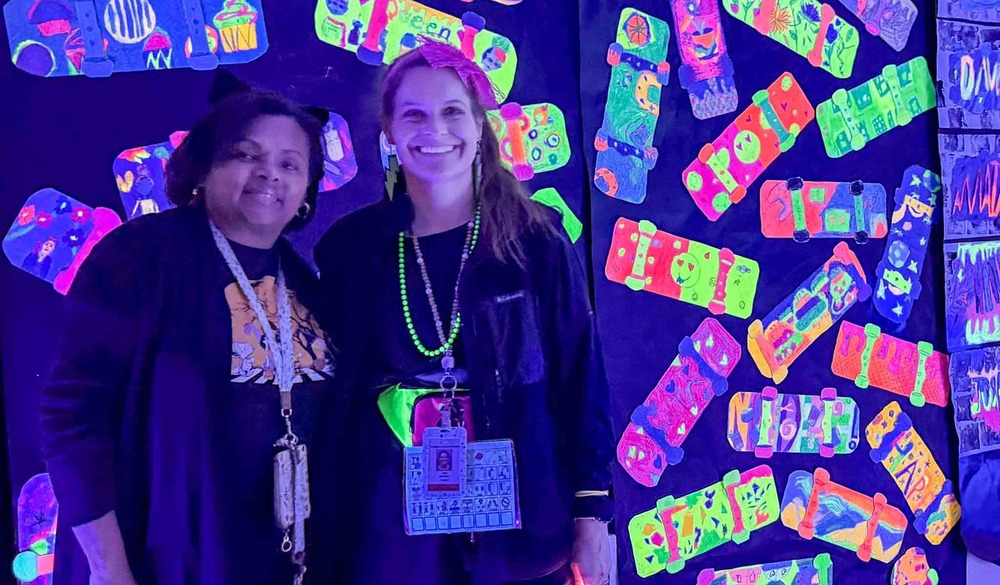 Teachers in front of a glow wall