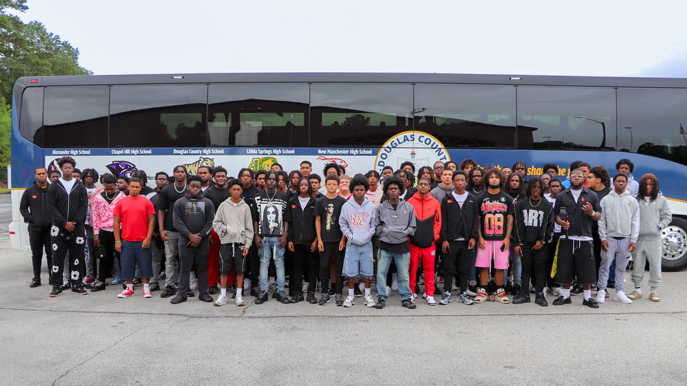 NMHS students and coaches in front of a new DCSS motorcoach
