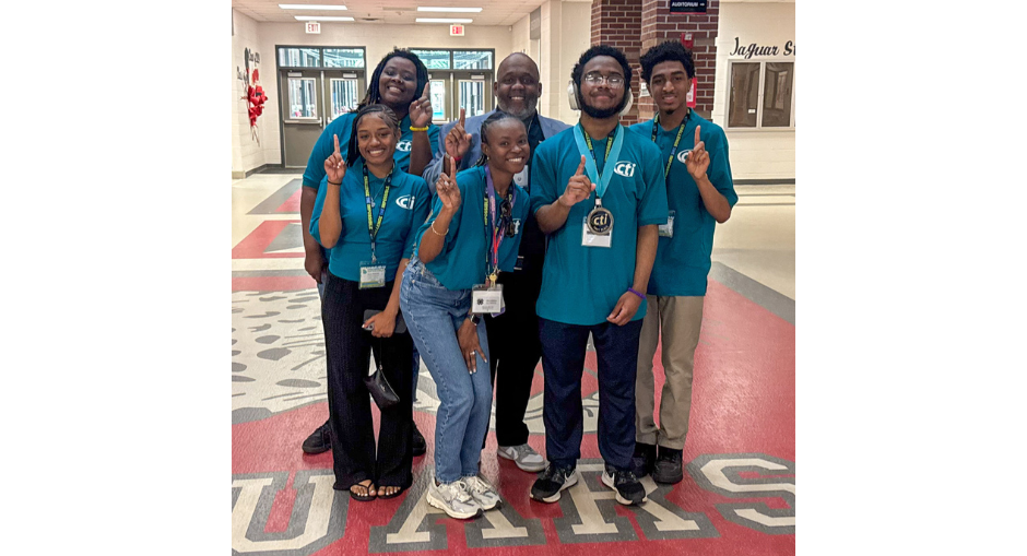 New Manchester High's Benjamin Cook shows off his medal with fellow students and teachers for winning the Computer Applications first place award at the CTI Conference.