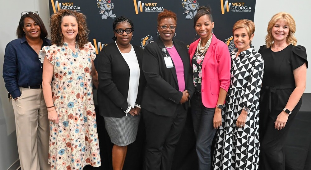 Staff members including Tekmekia Gilchrist pose for a group photo.