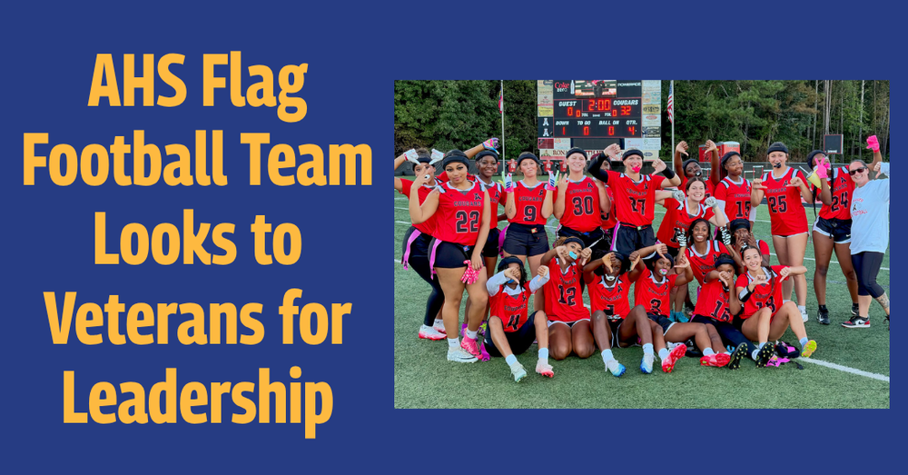 Alexander High School flag football players in red jerseys pose and smile on the field in front of a scoreboard. Text reads: “AHS Flag Football Team Looks to Veterans for Leadership.”
