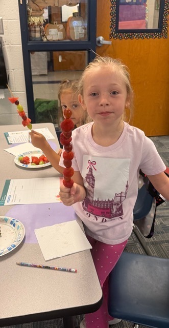 children eating fruit kabobs