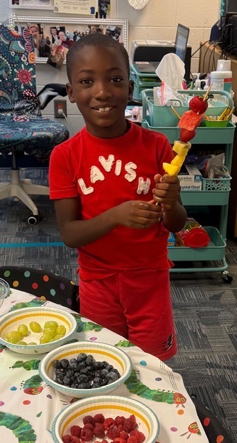 children eating fruit kabobs