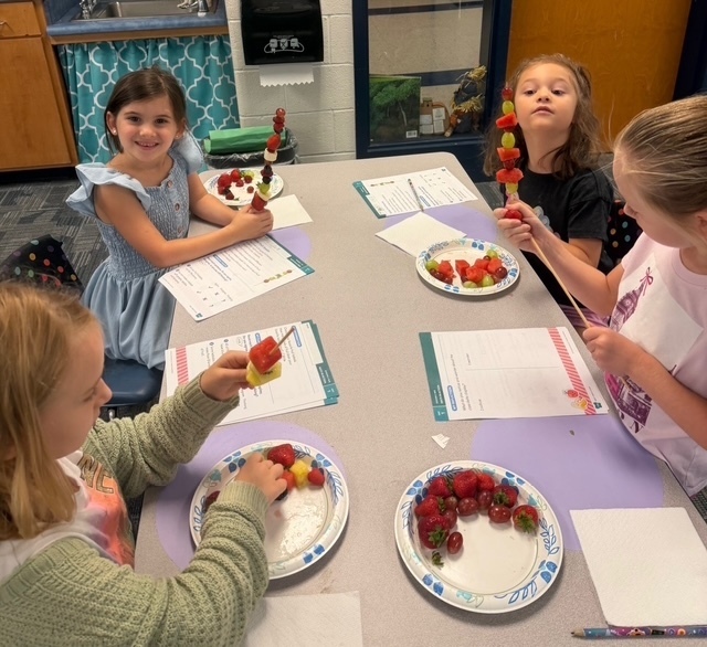 children eating fruit kabobs